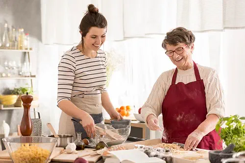 Haushaltshilfe und Seniorin am Kochen